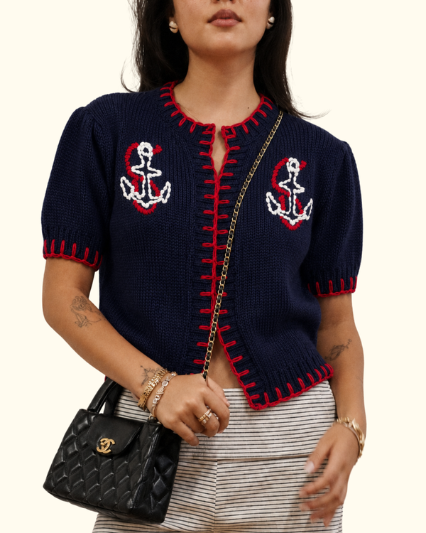 Model wearing Anchor Knit Cardigan in Navy with embroidered anchor details and red whipstitch trim