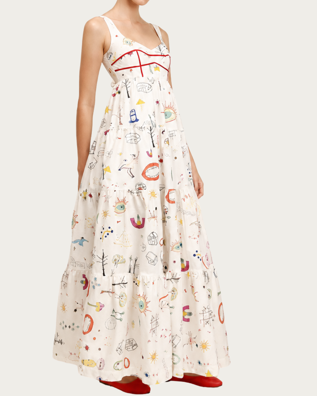 Side view of Doody Dress Ivory with tiered skirt and red contrast piping
