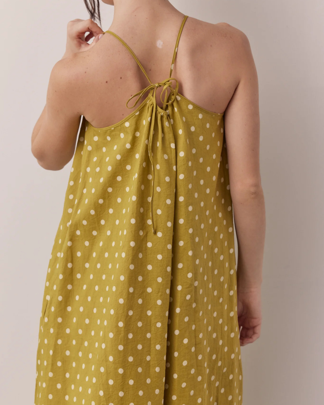 Back tie detail of Linen Polka Dot Tie Back Dress in Moss