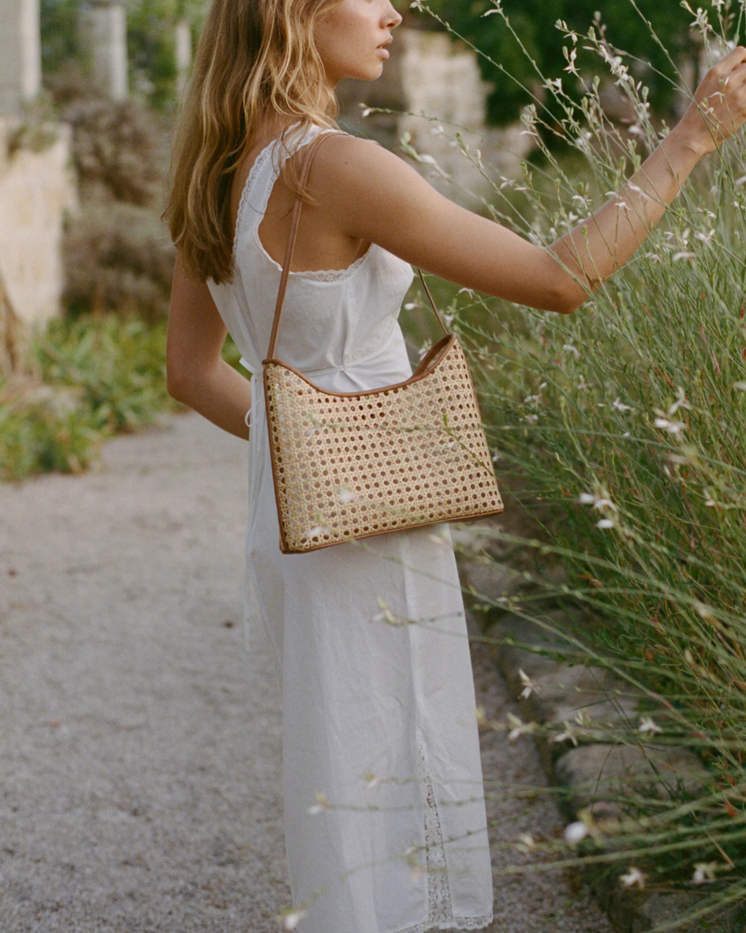 Model wearing Marni Bag Rattan Copper with white dress