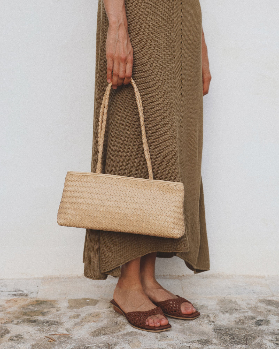 Model holding Naomi Bag Caramel woven leather shoulder bag
