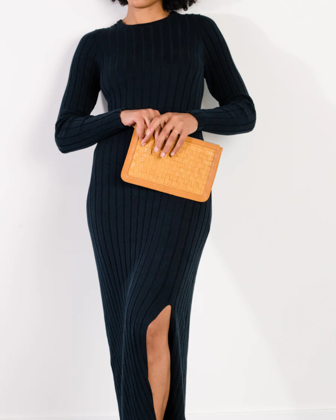 Model holding Nesmia Basketweave Clutch in Cognac with basketweave leather texture