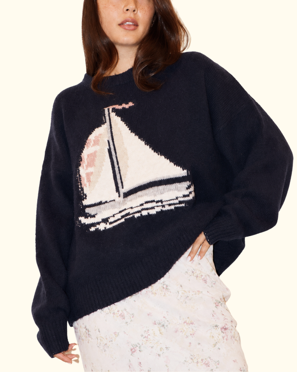 Model wearing Sailboat Fuzzy Knit Sweater in Navy with cream sailboat graphic