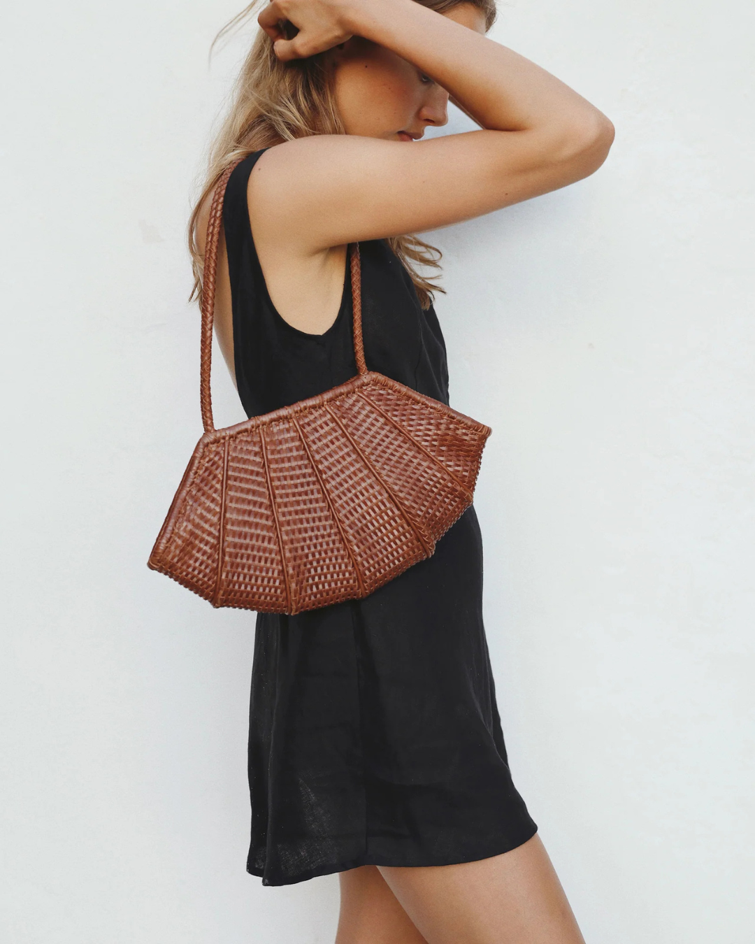Model wearing Venera Bag Sienna handwoven leather shoulder bag with black dress